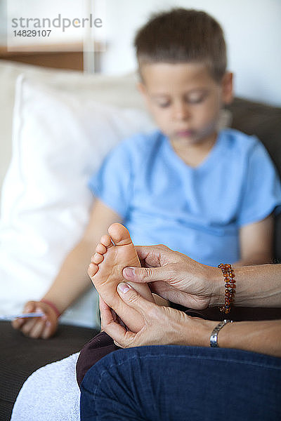 Reportage über Fußreflexzonenmassage bei Kindern. Der Fußreflexologe behandelt Kinder ab dem Alter von 5 Jahren aufwärts. Die Fußreflexzonenmassage wirkt sich auf ihre Konzentration  ihr Gedächtnis  ihr Gleichgewicht  ihre Gelassenheit und ihren Schlaf aus. Ein 5 Jahre alter Junge in einer Sitzung.