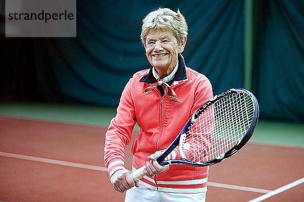 Eine ältere Person spielt Tennis.