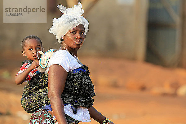 Afrikanische Mutter trägt ihr Baby auf dem Rücken.