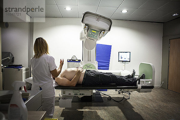 Reportage in einem radiologischen Zentrum in Haute-Savoie  Frankreich. Ein Techniker bereitet einen Patienten für eine Arthographie der Schulter vor.
