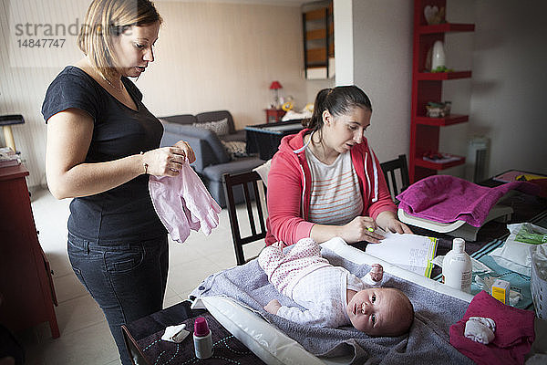Reportage über eine unabhängige Hebamme bei Hausbesuchen nach der Geburt. Die Hebamme füllt die Krankenakte des Babys aus.