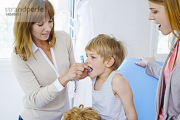 Ein Arzt gibt einem Kind Homöopathie.