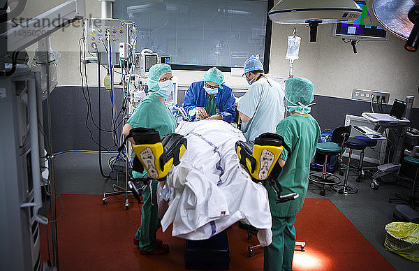 Reportage in einem Operationssaal während einer Hysterektomie mit dem da Vinci Roboter®. Der Anästhesist und die Anästhesieschwester bereiten die Patientin auf die Operation vor.