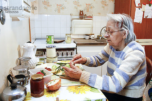 Eine ältere Frau kocht in ihrem Haus  unterstützt von ihrer Tochter  die ihr Vormund ist.