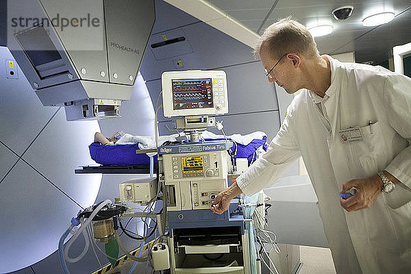 Reportage über das Rinecker Protonentherapiezentrum in München  Deutschland. Das Zentrum verfügt über die modernsten Geräte für die Protonentherapie. Bei der Protonentherapie werden Krebszellen bestrahlt  indem ein Protonenstrahl auf den Kern des Tumors konzentriert wird  während die