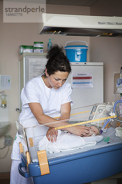 Reportage aus der Neonatologie der Stufe 2 in einem Krankenhaus in Haute-Savoie  Frankreich. Eine Hilfskraft beruhigt ein Neugeborenes  das nach dem Einatmen von Fruchtwasser unter Atemnot leidet.