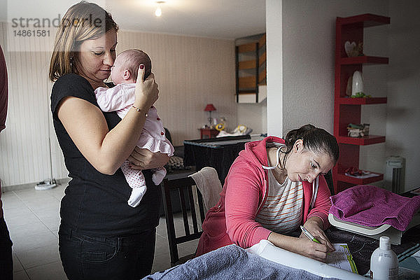 Reportage über eine unabhängige Hebamme bei Hausbesuchen nach der Geburt. Die Hebamme füllt die Gesundheitsakten des Babys aus.