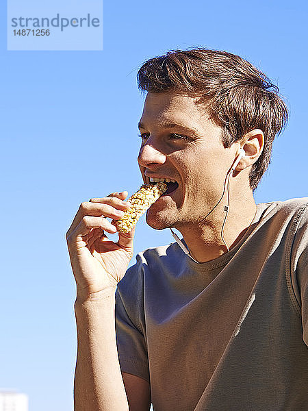 Ein Mann isst einen Energieriegel.