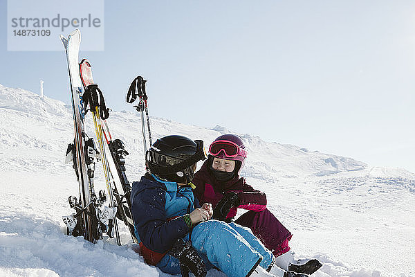 Kinder ruhen sich beim Skifahren in den Bergen aus