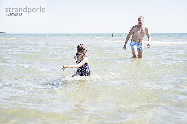 Vater spielt mit Tochter im Meer
