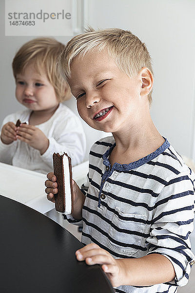 Lächelnder Junge mit Keks in der Hand