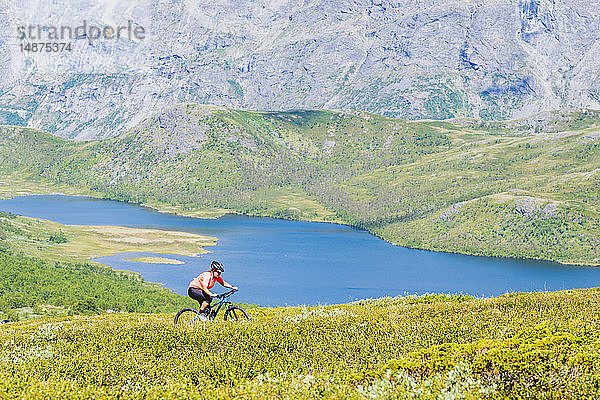 Frau fährt Fahrrad in den Bergen