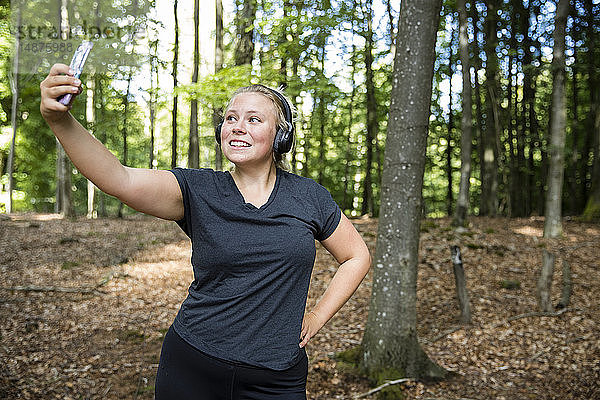 Frau mit Kopfhörern im Wald