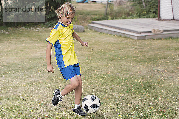 Junge spielt Fußball im Freien