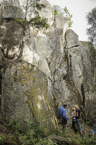 Drei Personen bereiten sich auf das Klettern vor