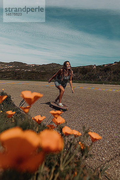 Junge Skateboarderin beim Skateboarden entlang einer Landstraße  Jalama  Kalifornien  USA