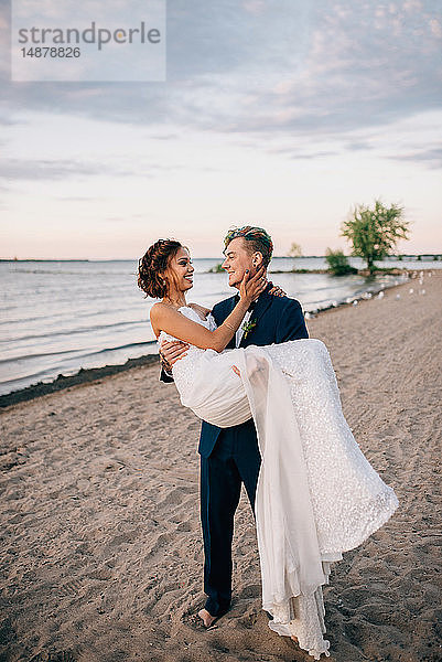 Romantischer Bräutigam trägt Braut am Seeufer  Ontariosee  Toronto  Kanada