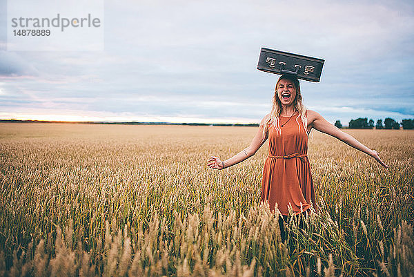 Frau balanciert Koffer auf dem Kopf im Weizenfeld  Edmonton  Kanada
