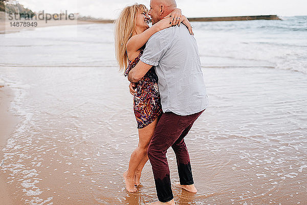 Pärchen umarmen und küssen am Strand