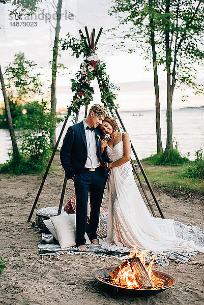 Braut und Bräutigam stehen am Lagerfeuer am Seeufer  Ontariosee  Toronto  Kanada