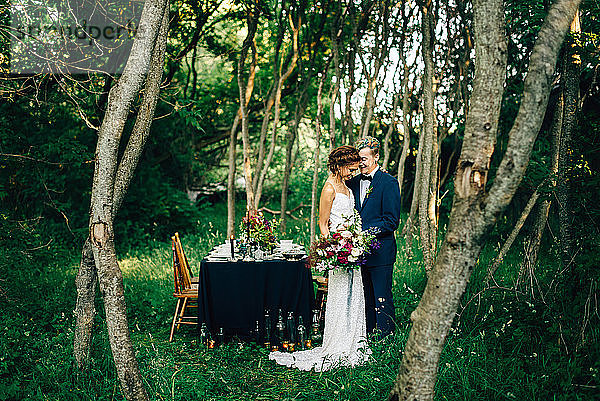 Romantische Braut und Bräutigam am Waldempfangstisch