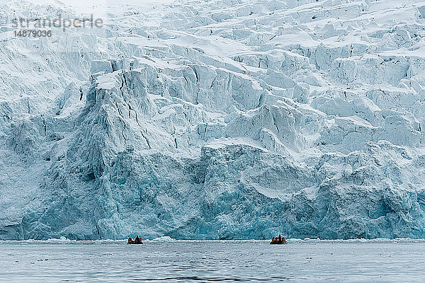 Touristen auf Schlauchbooten erkunden die polare Eiskappe nördlich von Spitzbergen  Norwegen