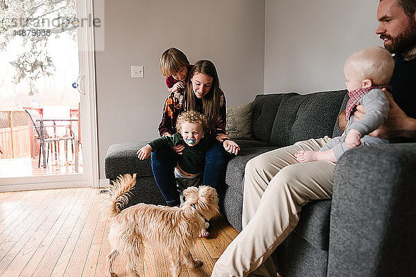 Familie und Söhne mit Haushund im Wohnzimmer