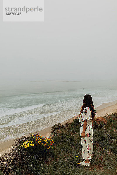 Junge Frau blickt von Klippe auf nebliges Meer  Jalama  Kalifornien  USA
