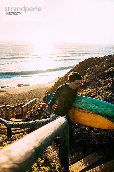 Surfer mit Surfbrett am Strand  Morro Bay  Kalifornien  Vereinigte Staaten