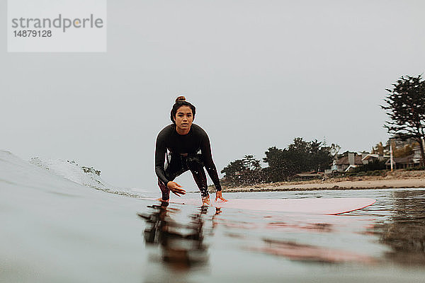 Junge Surferin beim Surfen auf neblig ruhiger See  Ventura  Kalifornien  USA