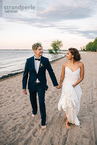 Romantische Braut und Bräutigam schlendern Hand in Hand am Seeufer  Ontariosee  Toronto  Kanada