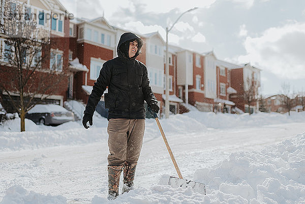 Mann räumt schneebedeckte Straße mit Schaufel  Toronto  Kanada
