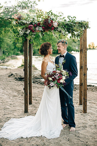 Romantische Braut und Bräutigam schauen sich am Seeufer an  Ontariosee  Toronto  Kanada