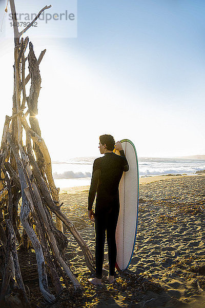Surfer mit Surfbrett am Strand  Morro Bay  Kalifornien  Vereinigte Staaten