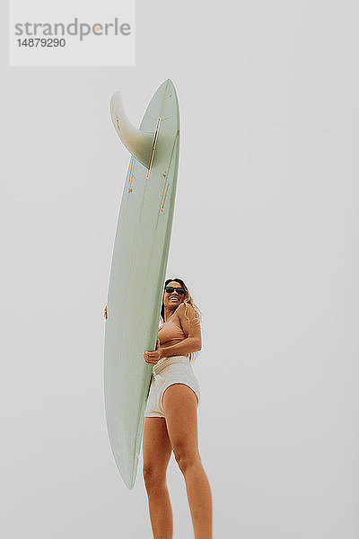 Junge Surferin  die ein Surfbrett in der Hand hält  niedriger Blickwinkel  Jalama  Ventura  Kalifornien  USA