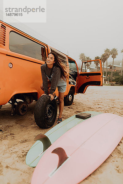 Junge Frau wechselt am Strand den Reifen eines Wohnmobils  Jalama  Kalifornien  USA