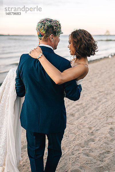 Romantischer Bräutigam trägt Braut am Seeufer  Rückansicht  Lake Ontario  Toronto  Kanada