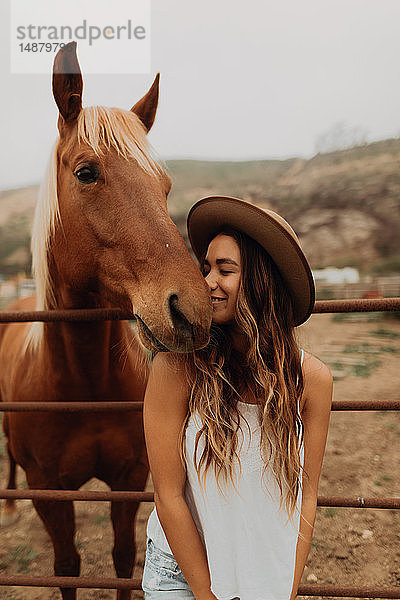 Junge Frau mit Filzhut Nase an Nase mit Pferd  Jalama  Kalifornien  USA