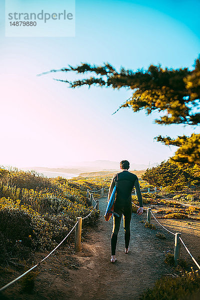 Surfer mit Surfbrett am Strand  Morro Bay  Kalifornien  Vereinigte Staaten