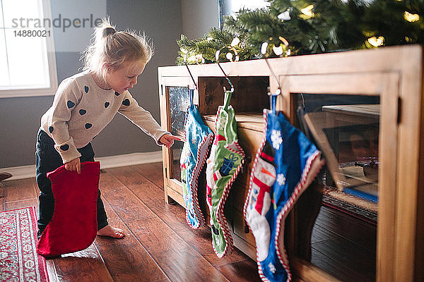 Kleinkind Mädchen hängt Weihnachtsstrümpfe auf
