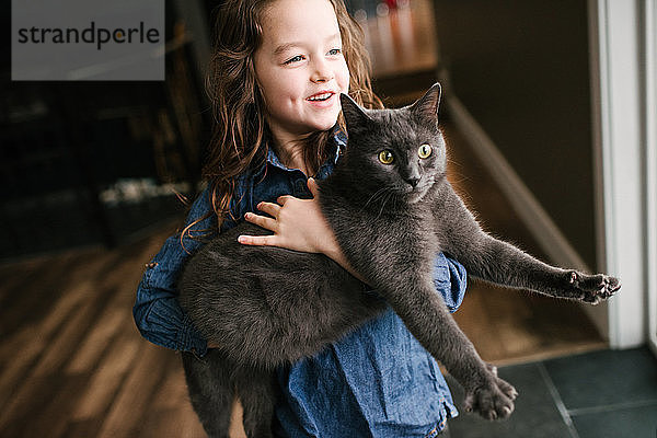 Kleines Mädchen spielt zu Hause mit Katze
