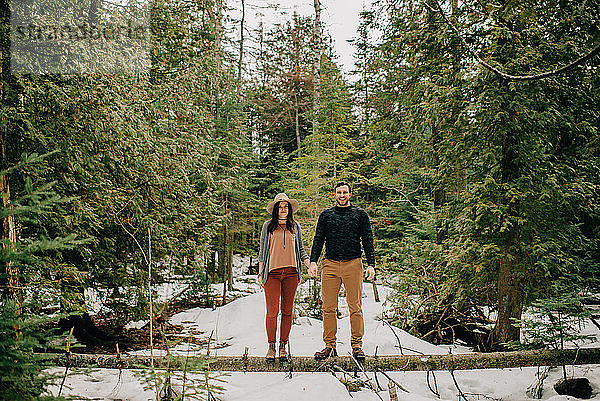 Ehepaar steht auf umgestürztem Baumstamm im Wald  Tobermory  Kanada