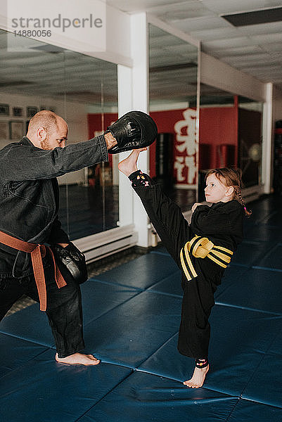 Trainer und Schüler üben Kickboxen im Studio