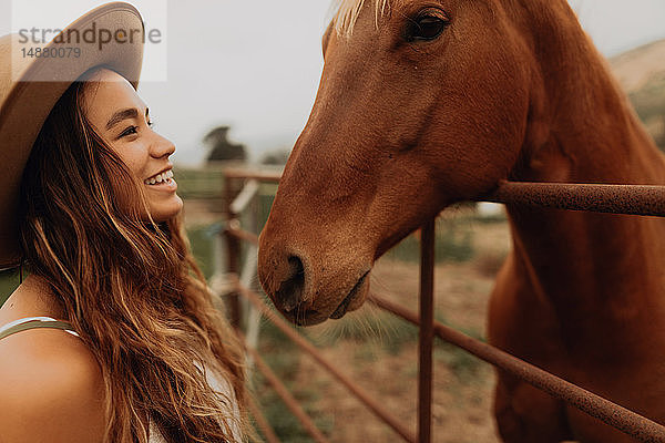 Junge Frau mit Filzhut von Angesicht zu Angesicht mit Pferd  Jalama  Kalifornien  USA
