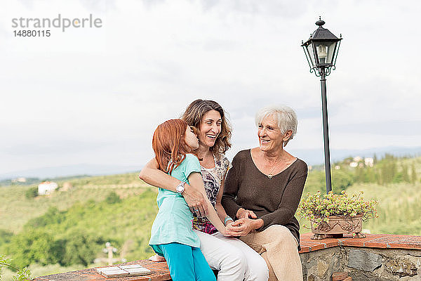Mädchen auf der Gartenterrasse mit Mutter und Großmutter