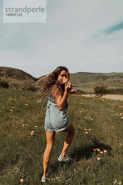 Junge Frau rennt im Feld der Wildblumen  Porträt  Jalama  Kalifornien  USA