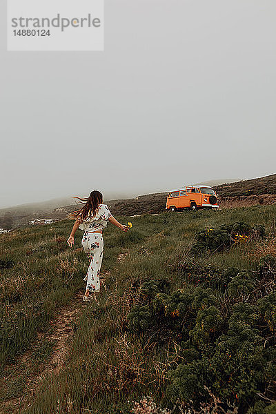 Junge Frau geht an der Küste auf ein Wohnmobil zu  Jalama  Kalifornien  USA