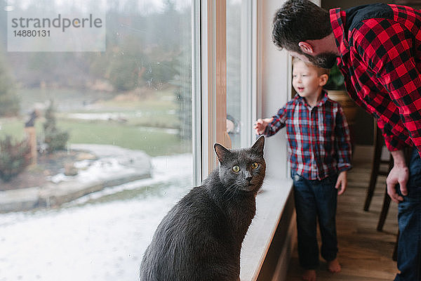 Vater und Sohn unterhalten sich zu Hause am Fenster