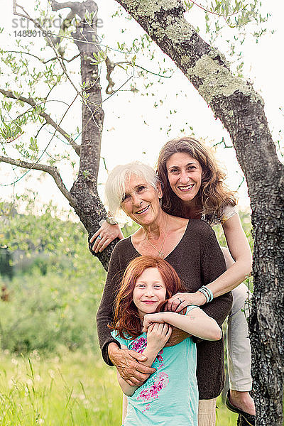 Mädchen am Gartenbaum mit Mutter und Großmutter  Porträt