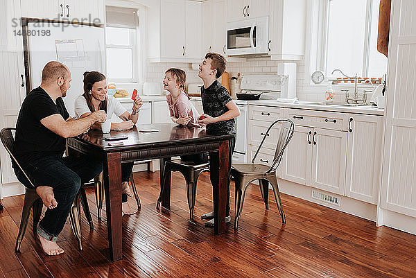 Familie von vier Spielkarten in der Küche